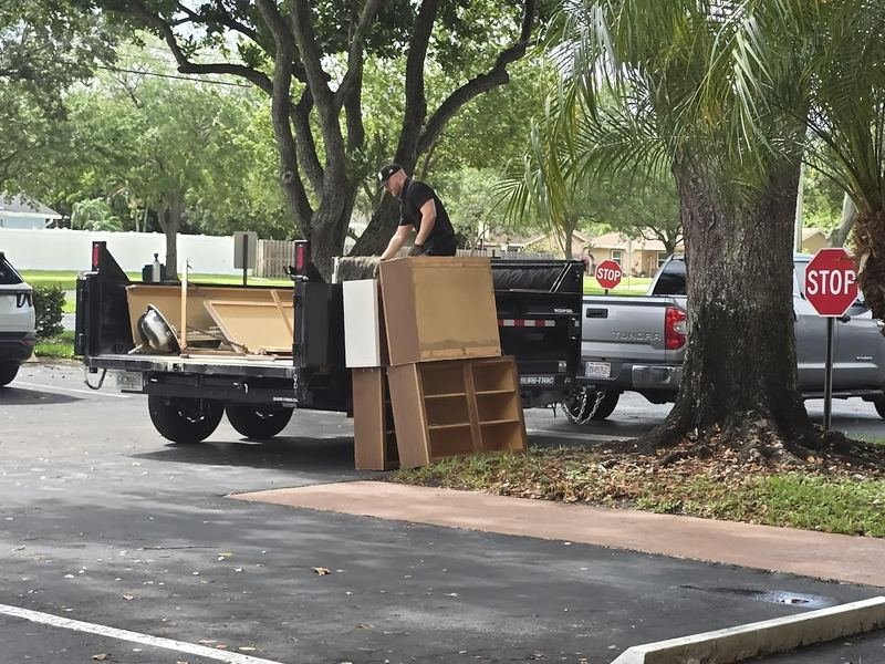 Tyler loading furniture and cabinets from a condo cleanout into the On-Call Hauler dump trailer